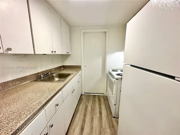 a kitchen with a stove top oven and sink