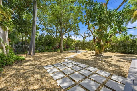 a view of a yard with plants and trees