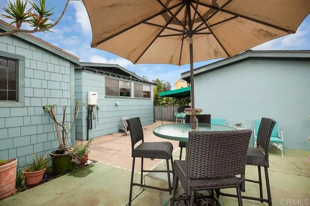 a view of a patio with table and chairs under an umbrella