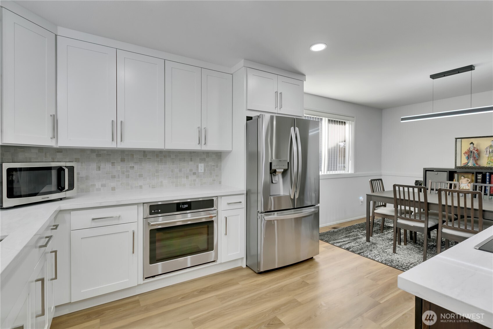28012 236th Avenue Southeast Maple Valley, WA 98038 - Photo 17 of 39 a kitchen with stainless steel appliances a stove a refrigerator a white table and chairs
