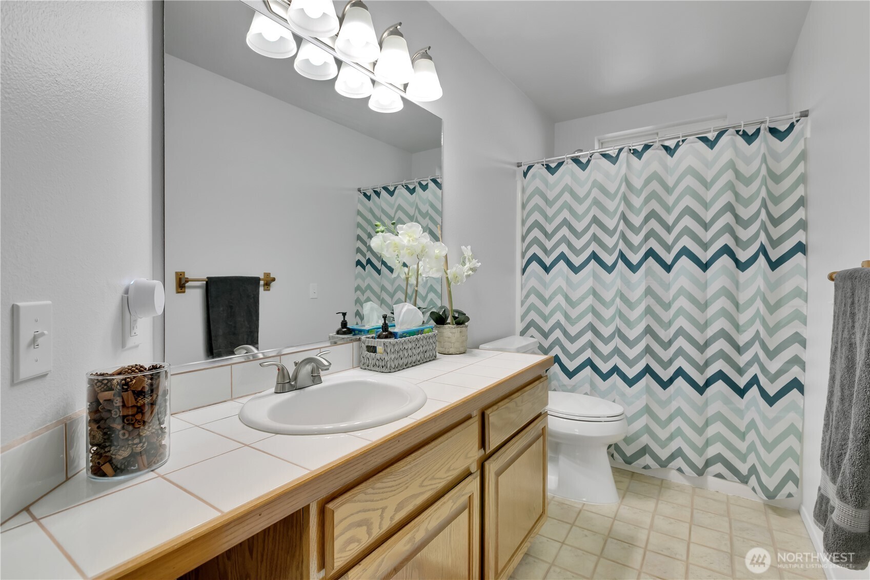 28012 236th Avenue Southeast Maple Valley, WA 98038 - Photo 26 of 39 a bathroom with a sink a toilet and a mirror