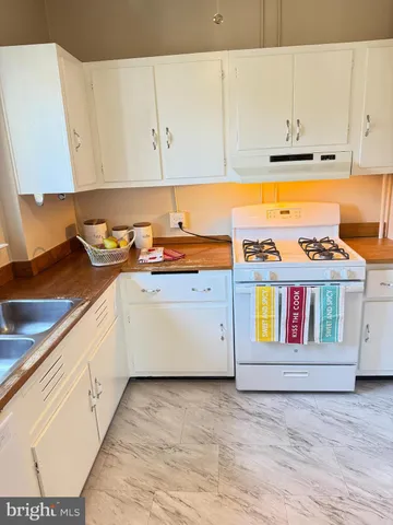 a kitchen with a stove and white cabinets