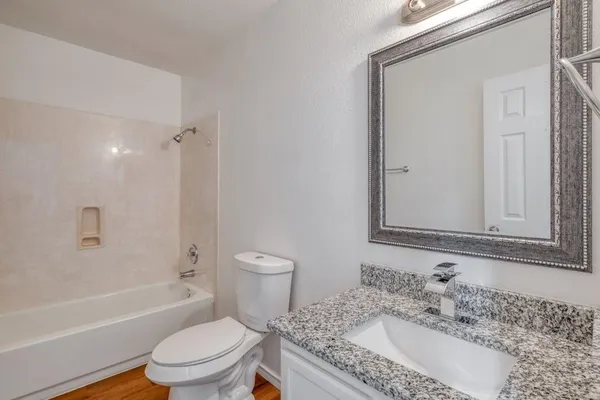 a bathroom with a granite countertop sink toilet and shower