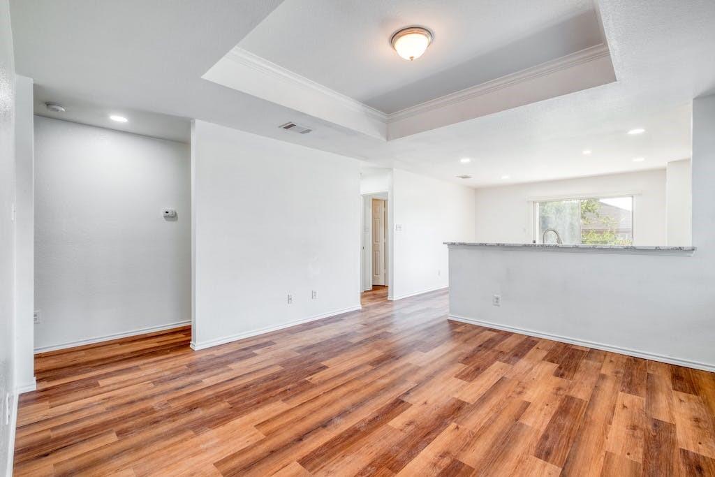 3415 Crownover Street Austin, TX 78725 - Photo 2 of 13 Spare room with crown molding, a raised ceiling, recessed lighting, and light wood-style floors