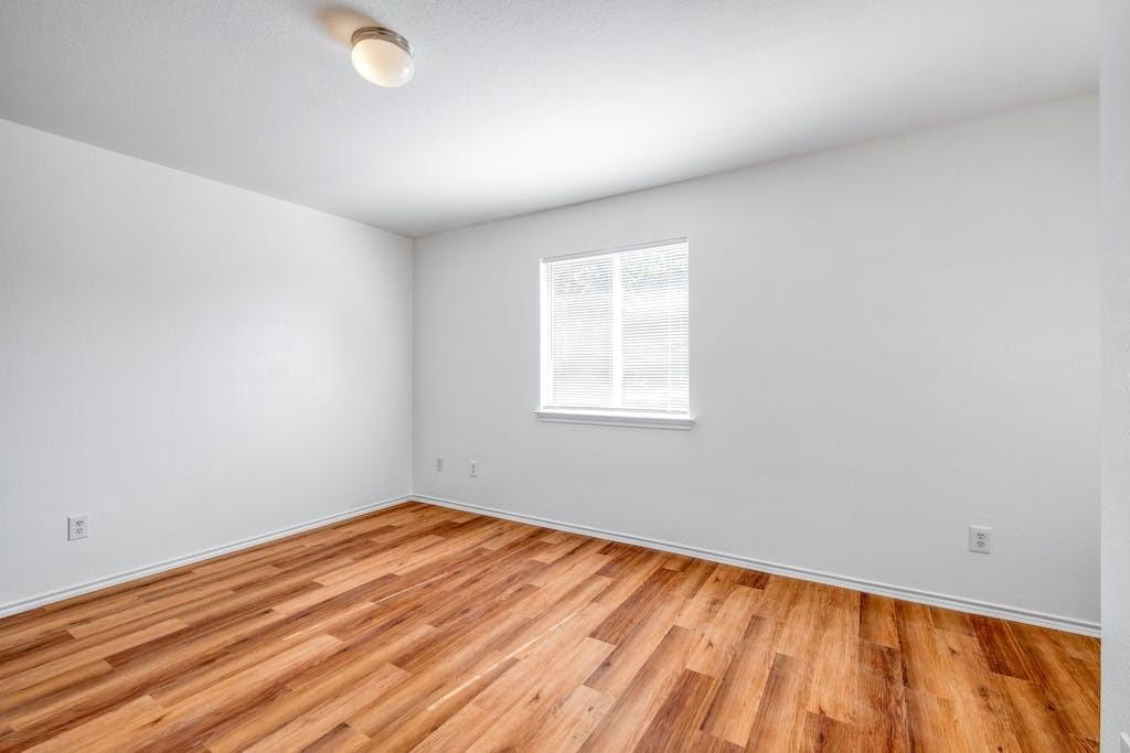 3415 Crownover Street Austin, TX 78725 - Photo 4 of 13 Empty room with light wood-style flooring and baseboards