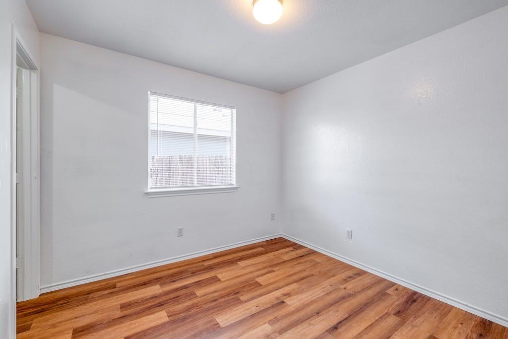 3415 Crownover Street Austin, TX 78725 - Photo 10 of 13 Spare room featuring wood finished floors and baseboards