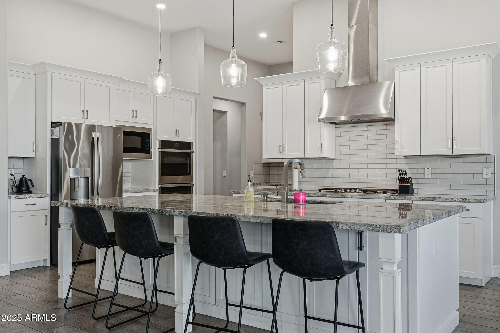 22940 East Camacho Road Queen Creek, AZ 85142 - Photo 19 of 68 a kitchen with stainless steel appliances granite countertop a sink a stove a refrigerator and island with wooden floor
