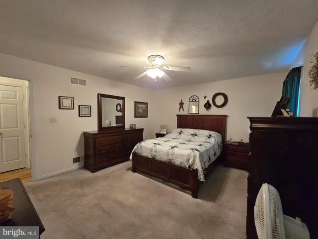 a bedroom with a bed window and dresser