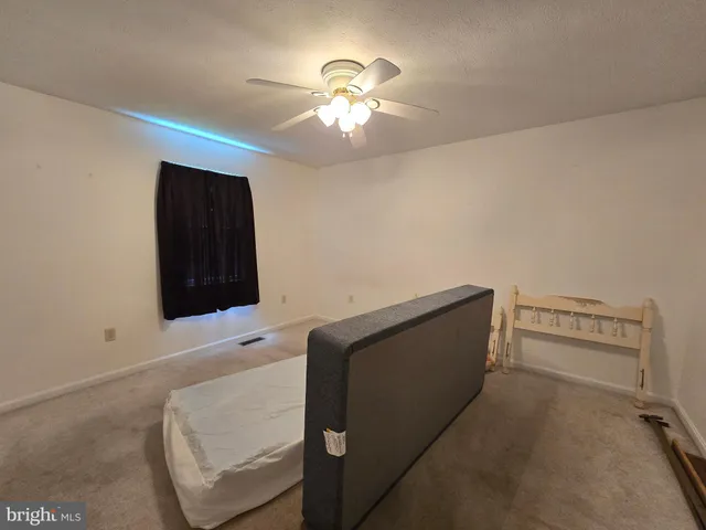 a living room with furniture and a ceiling fan