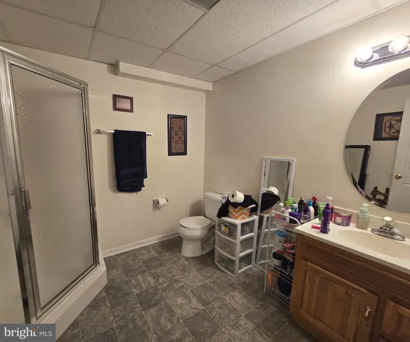 a living room with furniture a flat screen tv and a refrigerator