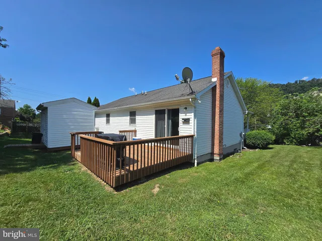 a view of a backyard with a garden and deck