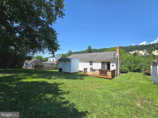 a view of a house with a big yard couches and a large tree
