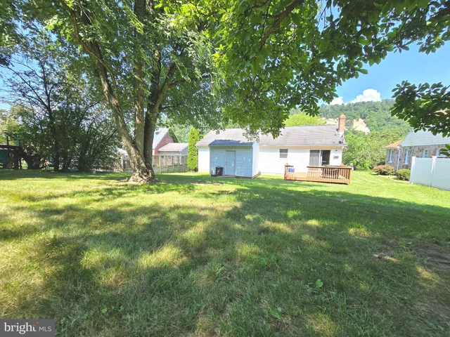 a view of a house with a big yard and large trees