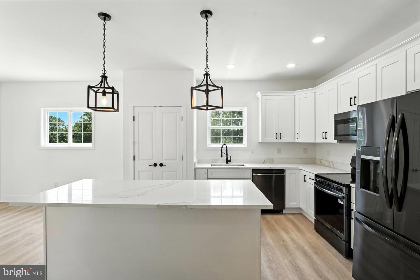 10704 Rixeyville Road Culpeper, VA 22701 - Photo 14 of 35 a kitchen with stainless steel appliances a stove a sink a refrigerator a center island and cabinets