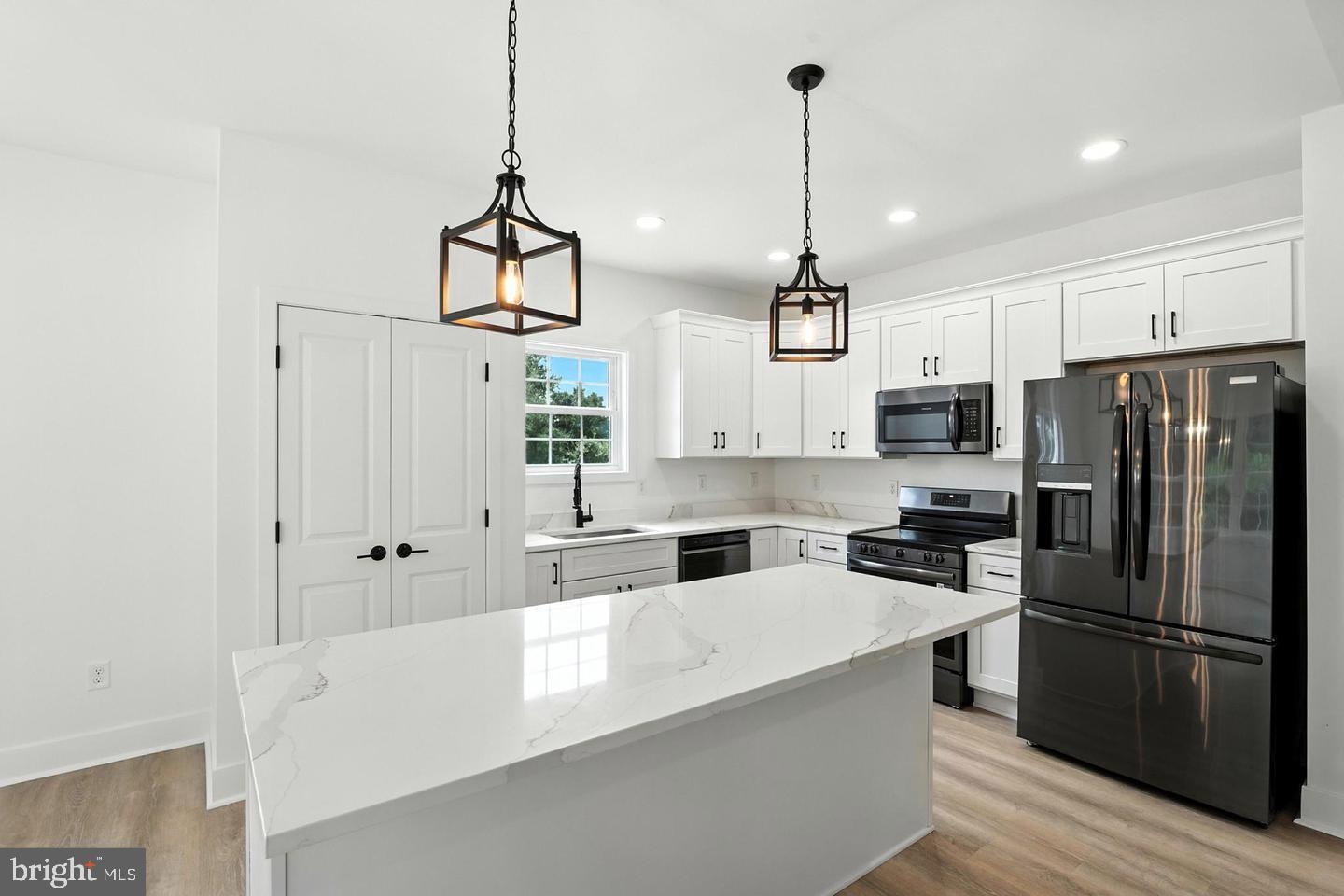 10704 Rixeyville Road Culpeper, VA 22701 - Photo 15 of 35 a kitchen with stainless steel appliances a refrigerator a sink dishwasher a stove and white cabinets with wooden floor