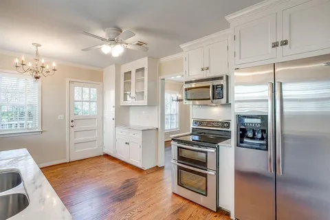 a kitchen with white cabinets and stainless steel appliances