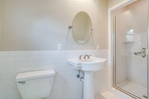 a bathroom with a sink a toilet and shower
