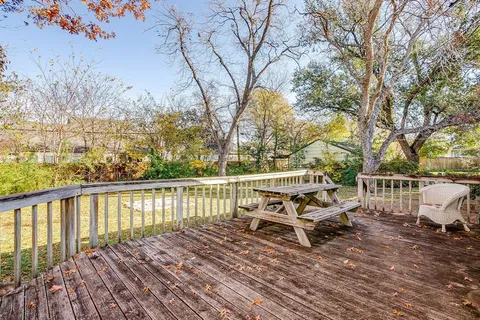 a view of house with wooden deck and trees