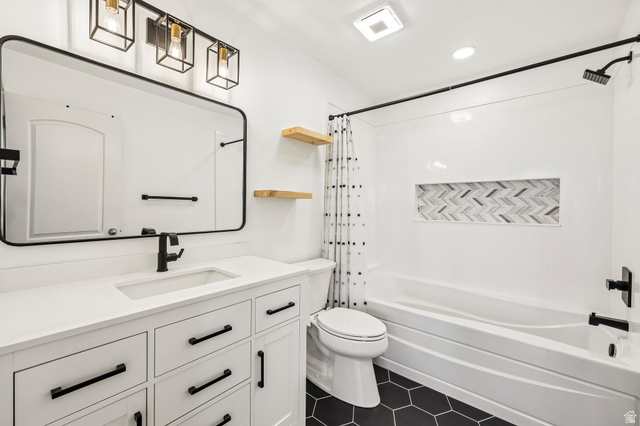 3215 West 450 North West Point, UT 84015 - Photo 16 of 40 Bathroom featuring a white vanity with integrated sink, black hexagonal floor tiling, and a tub with a tiled niche