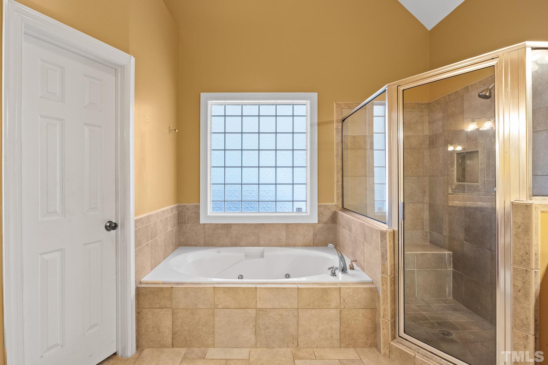 836 Crown Crossing Lane Raleigh, NC 27610 - Photo 12 of 31 a bathroom with a granite countertop bathtub and shower