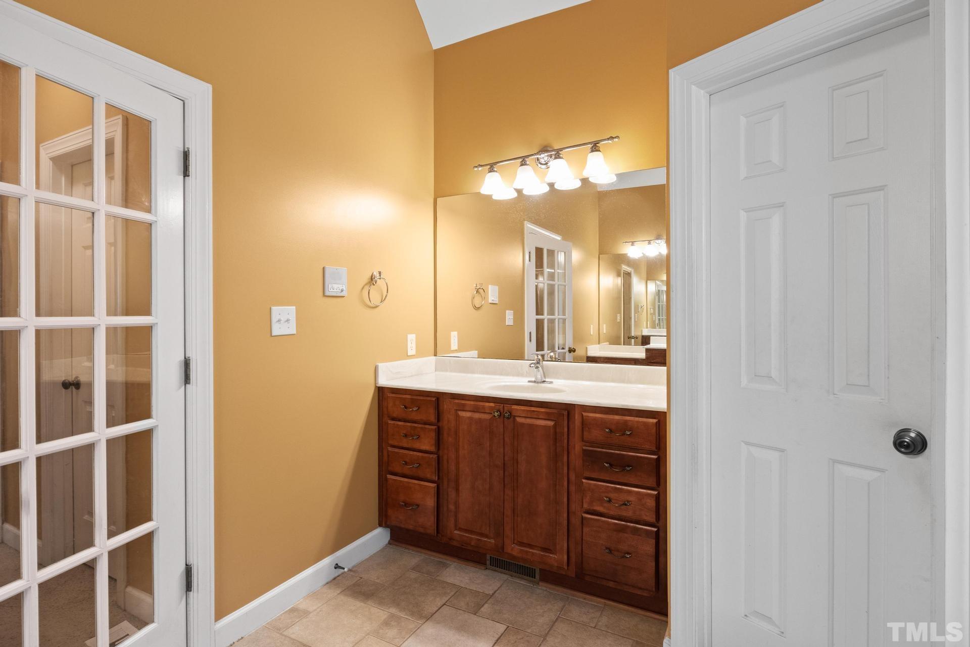 836 Crown Crossing Lane Raleigh, NC 27610 - Photo 13 of 31 a bathroom with a double vanity sink and a mirror