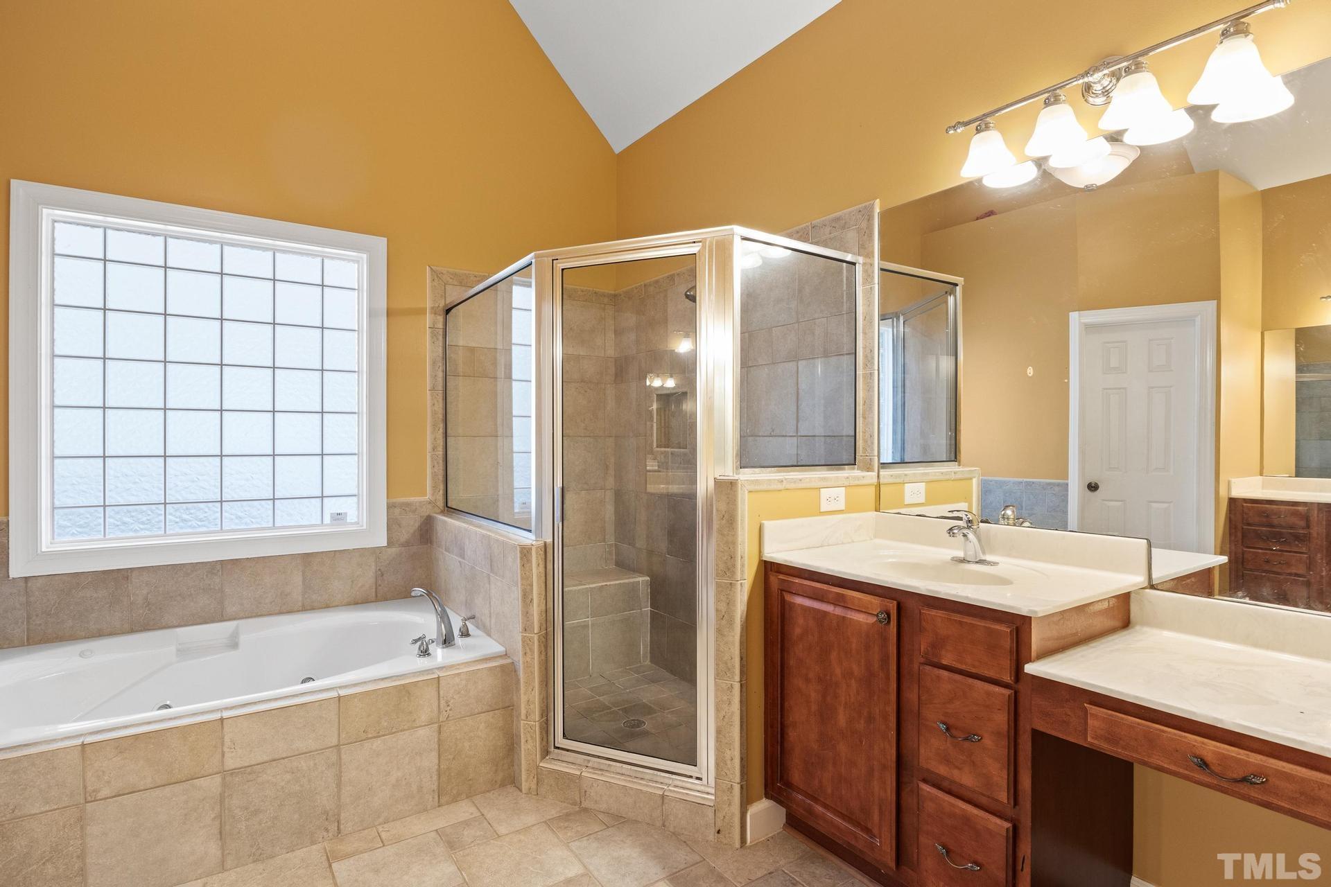 836 Crown Crossing Lane Raleigh, NC 27610 - Photo 14 of 31 a bathroom with a tub sink and mirror