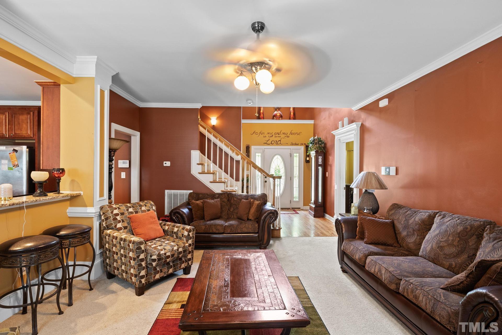 836 Crown Crossing Lane Raleigh, NC 27610 - Photo 15 of 31 a living room with furniture a chandelier and a large mirror