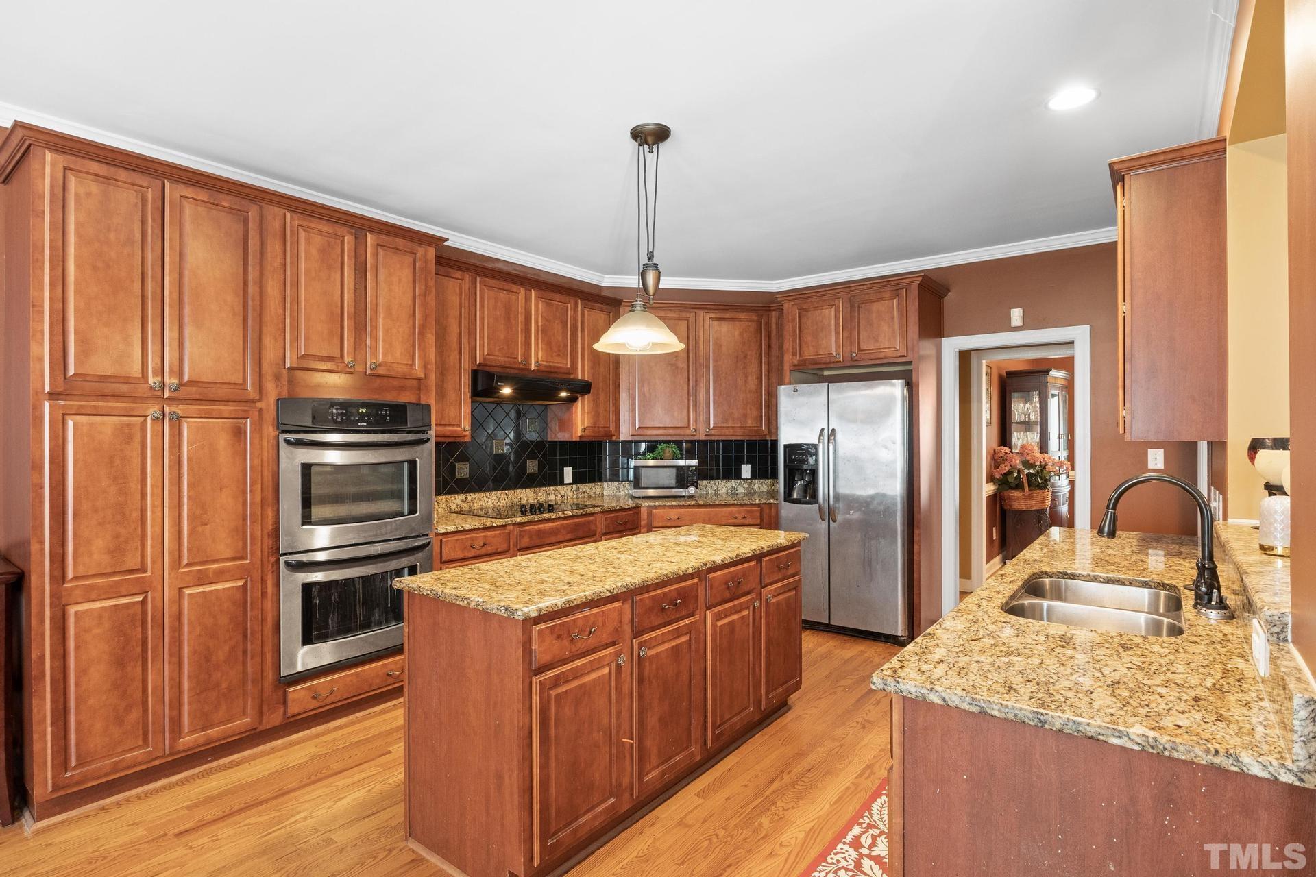 836 Crown Crossing Lane Raleigh, NC 27610 - Photo 17 of 31 a large kitchen with kitchen island a large counter top stainless steel appliances and cabinets