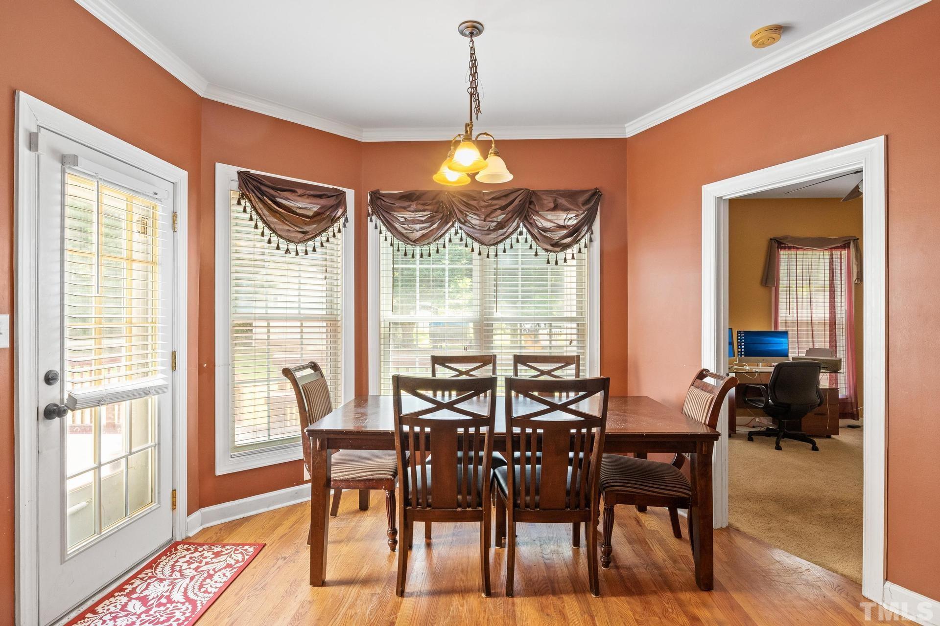 836 Crown Crossing Lane Raleigh, NC 27610 - Photo 19 of 31 a view of a dining room with furniture window and wooden floor