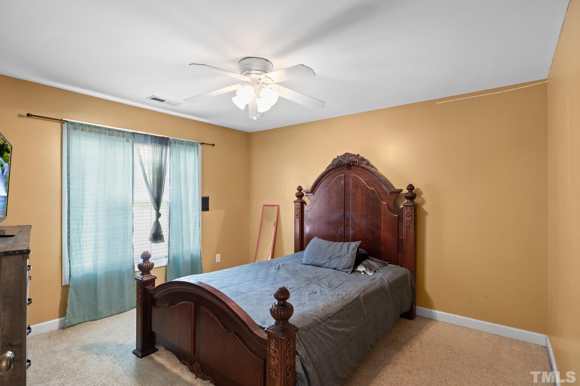 836 Crown Crossing Lane Raleigh, NC 27610 - Photo 24 of 31 a bed room with a bed and a chandelier