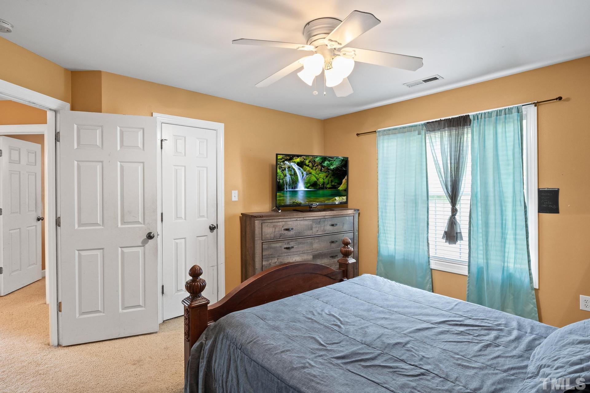 836 Crown Crossing Lane Raleigh, NC 27610 - Photo 25 of 31 a bedroom with a bed and a chandelier