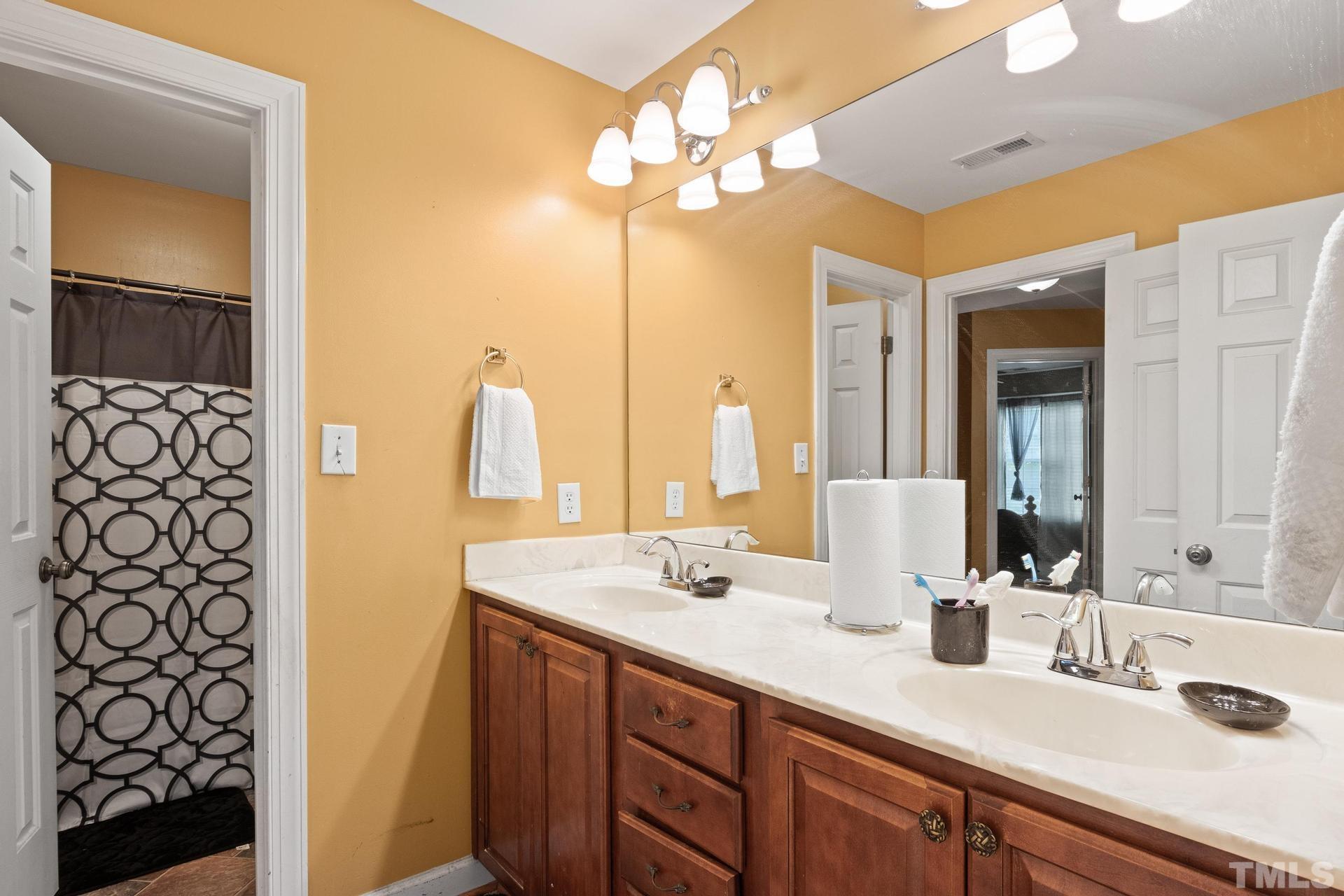 836 Crown Crossing Lane Raleigh, NC 27610 - Photo 29 of 31 a bathroom with a double vanity sink and a mirror