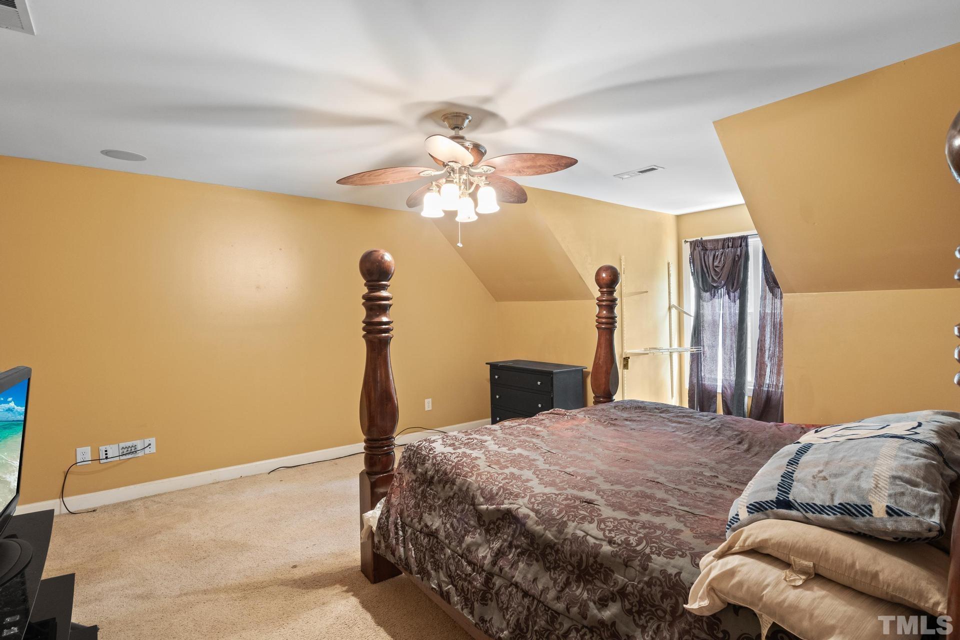 836 Crown Crossing Lane Raleigh, NC 27610 - Photo 30 of 31 a bedroom with a bed and a chandelier
