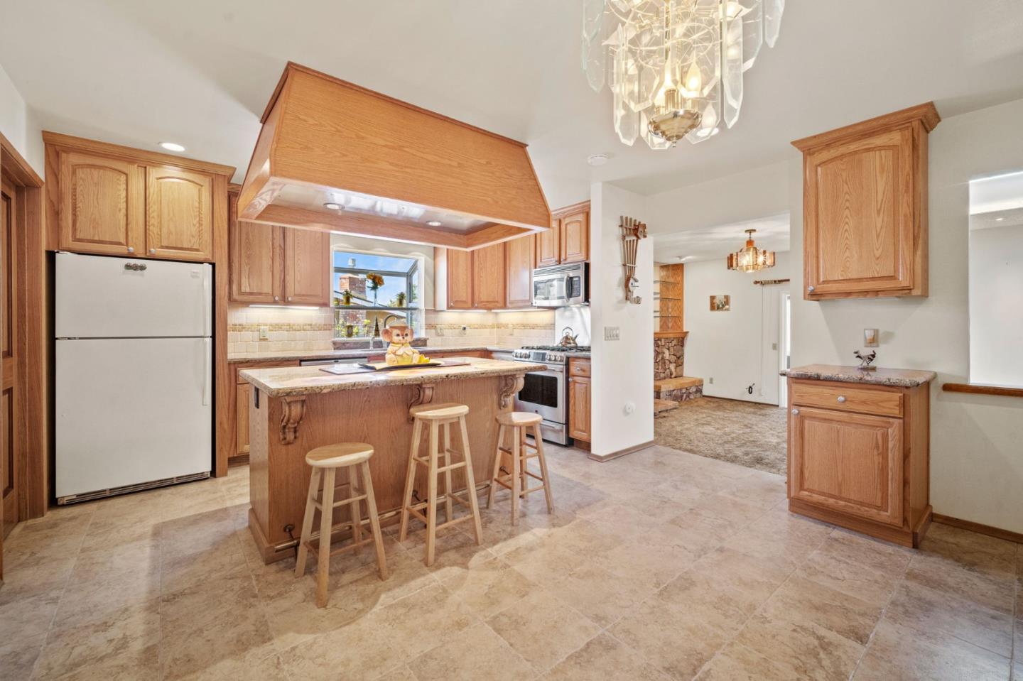 3060 Eddy Circle Marina, CA 93933 - Photo 5 of 35 a kitchen with a refrigerator a sink dishwasher with a dining table and chairs