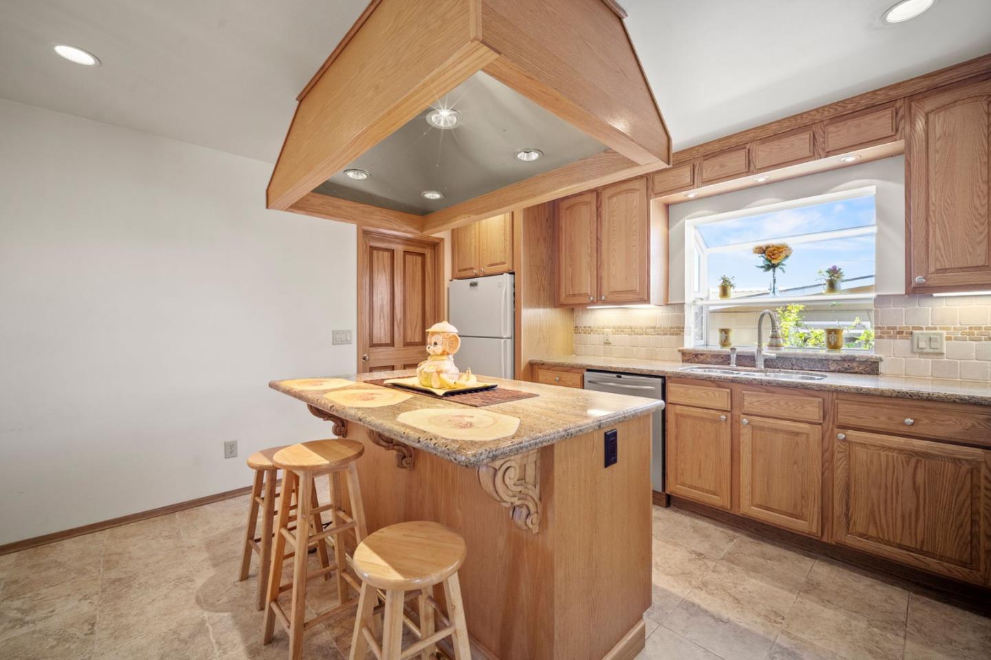 3060 Eddy Circle Marina, CA 93933 - Photo 6 of 35 a kitchen with a sink a stove a dining table and chairs