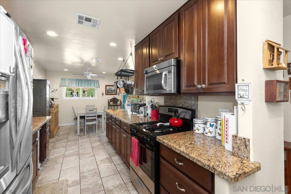 9254 Shadow Hill Road Santee, CA 92071 - Photo 12 of 34 a kitchen with stainless steel appliances granite countertop a sink stove and refrigerator