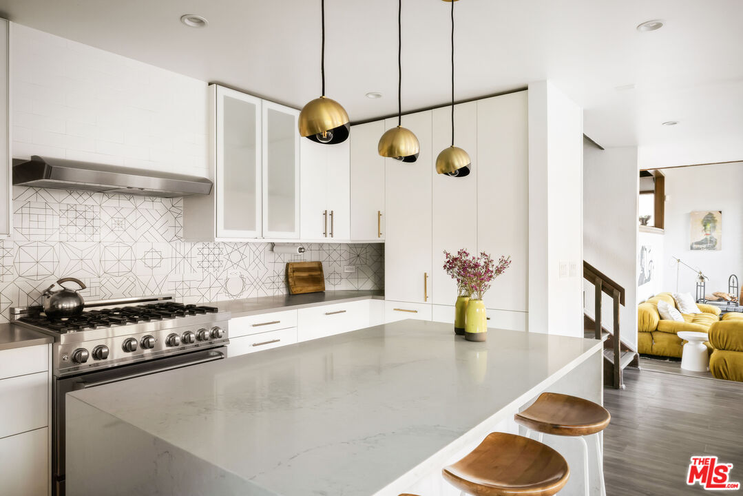 2690 Kennington Drive Glendale, CA 91206 - Photo 14 of 50 a kitchen with a stove a white cabinet and a granite countertops with wooden floor