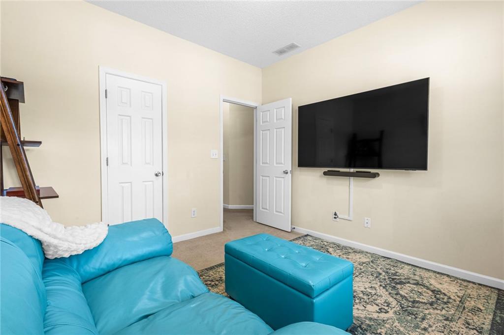 825 Lincoln Square Locust Grove, GA 30248 - Photo 24 of 29 a living room with furniture and a flat screen tv