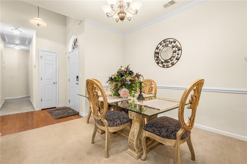 825 Lincoln Square Locust Grove, GA 30248 - Photo 5 of 29 a dining room with furniture and a chandelier