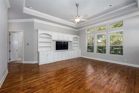 a view of empty room with wooden floor and chandelier