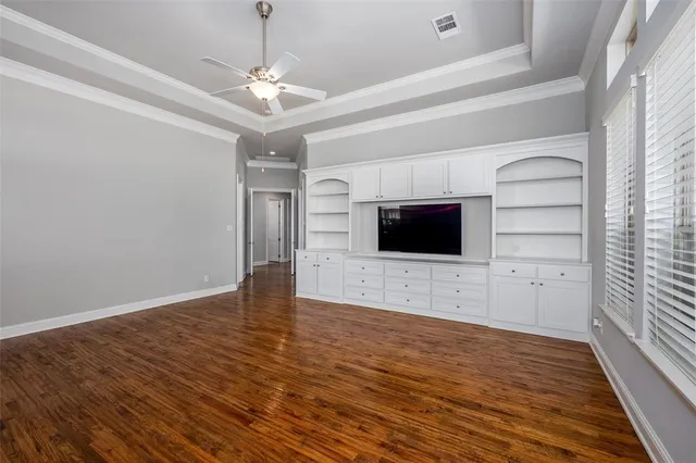 a view of a livingroom with an empty space & a window