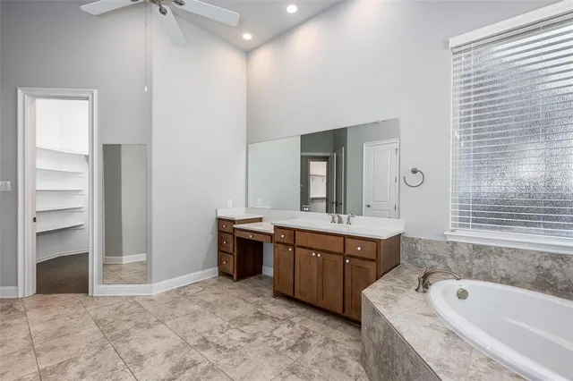 a spacious bathroom with a tub sink and mirror