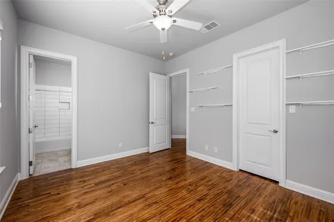 wooden floor in an empty room with a chandelier fan