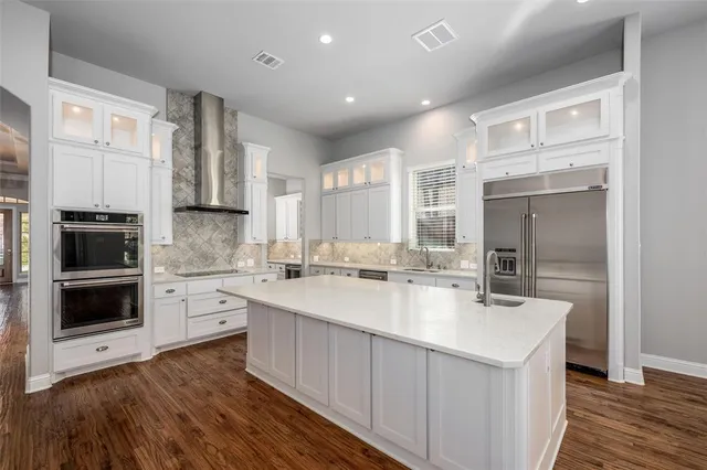 a large kitchen with kitchen island a sink stainless steel appliances and cabinets