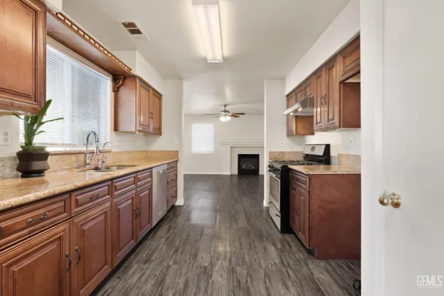 a kitchen with granite countertop a sink and white cabinets
