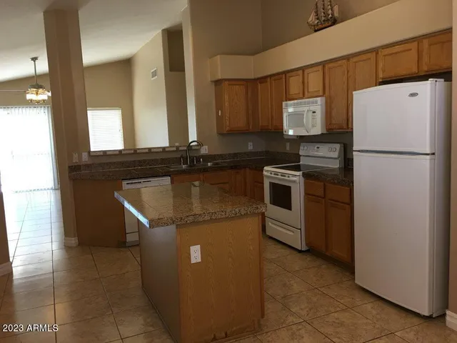 a kitchen with stainless steel appliances granite countertop a refrigerator a stove a sink and a microwave