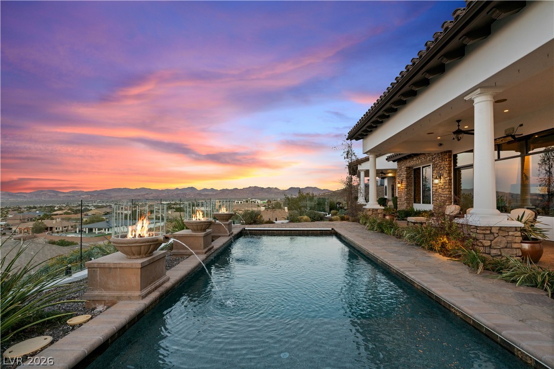 1123 Christian Road Henderson, NV 89002 - Photo 92 of 94 An inviting pool area with elegant fire features and sweeping mountain views at sunset.