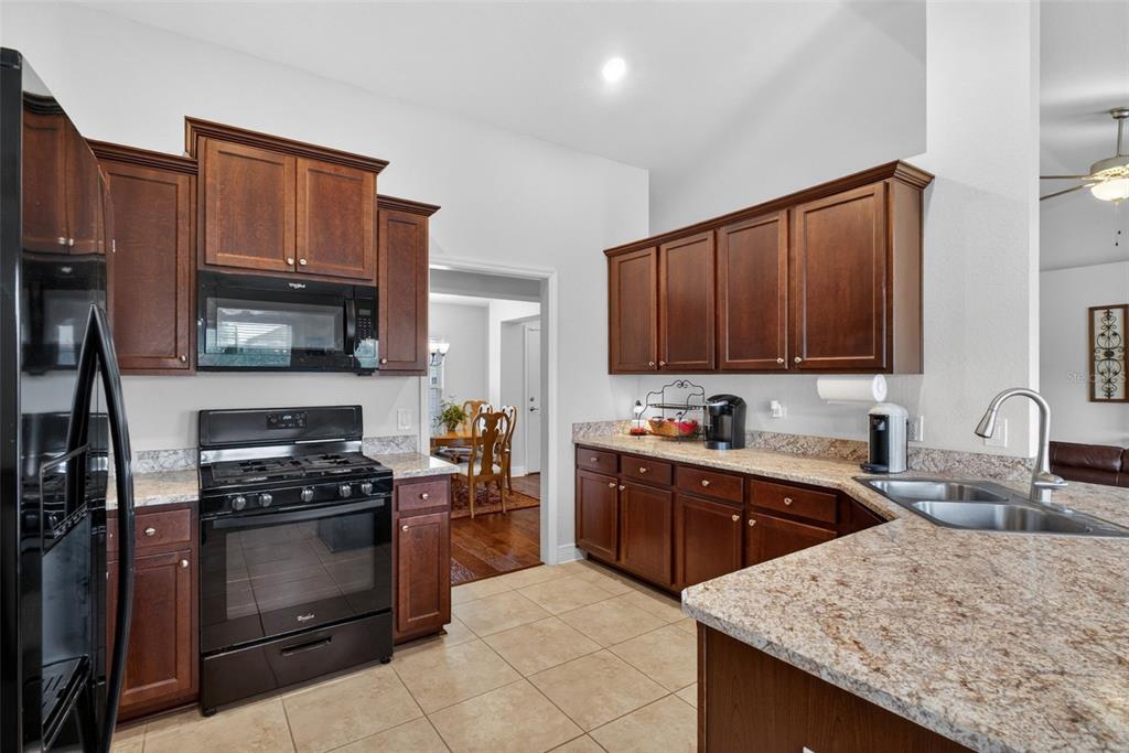 2429 Twin Lake View Road Winter Haven, FL 33881 - Photo 12 of 37 a kitchen with granite countertop a stove top oven microwave and cabinets