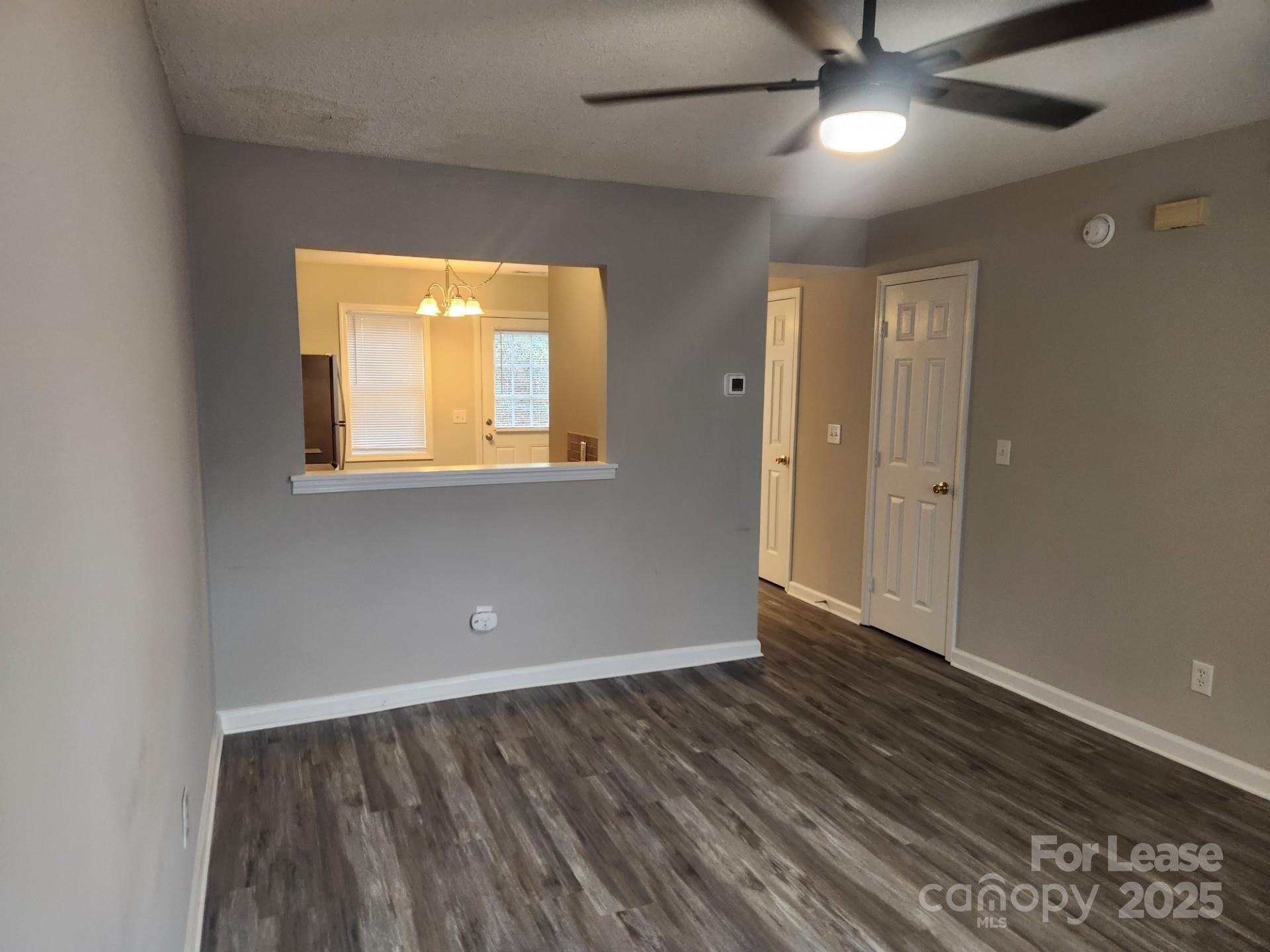157 Pounds Avenue Southwest Concord, NC 28025 - Photo 12 of 15 an empty room with wooden floor and windows