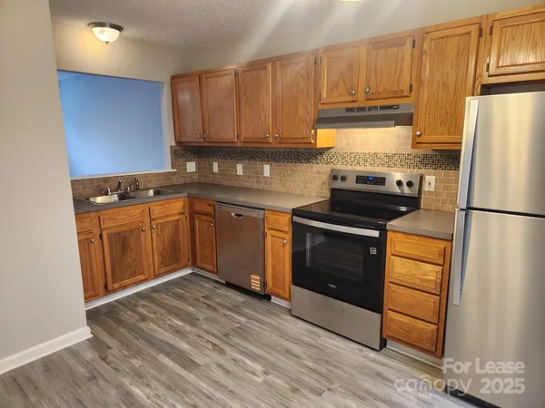 a kitchen with a refrigerator stove and wooden cabinets